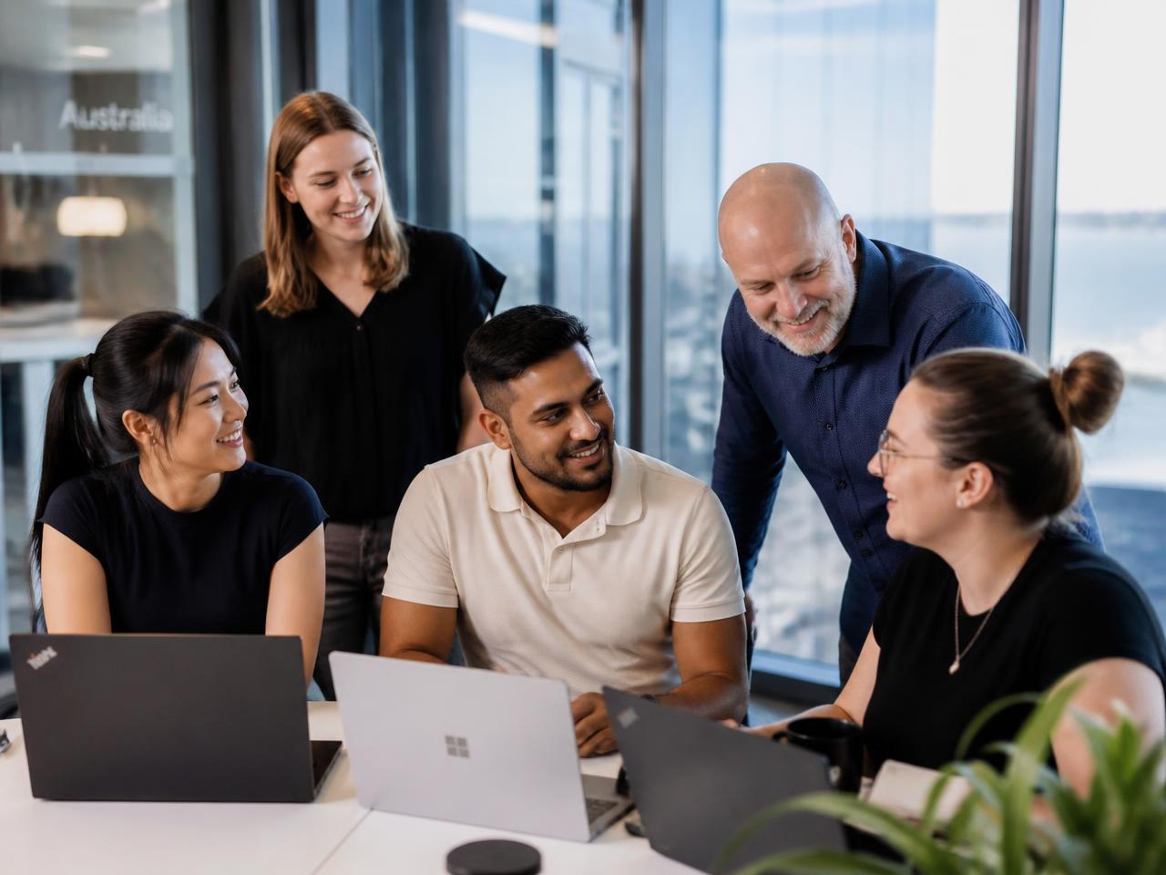 A diverse group of Australian technology professionals collaborating in a bright modern office
